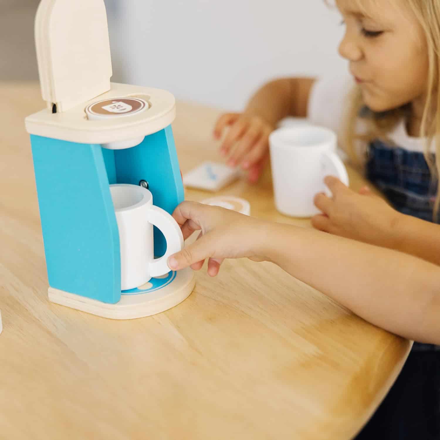 Melissa & Doug Brew & Serve Wooden Coffee Maker Set (Play Kitchen Accessories, Encourages Imaginative Play, A little girl is playing with a Melissa & Doug Brew and Serve Wooden Coffee Maker Set.