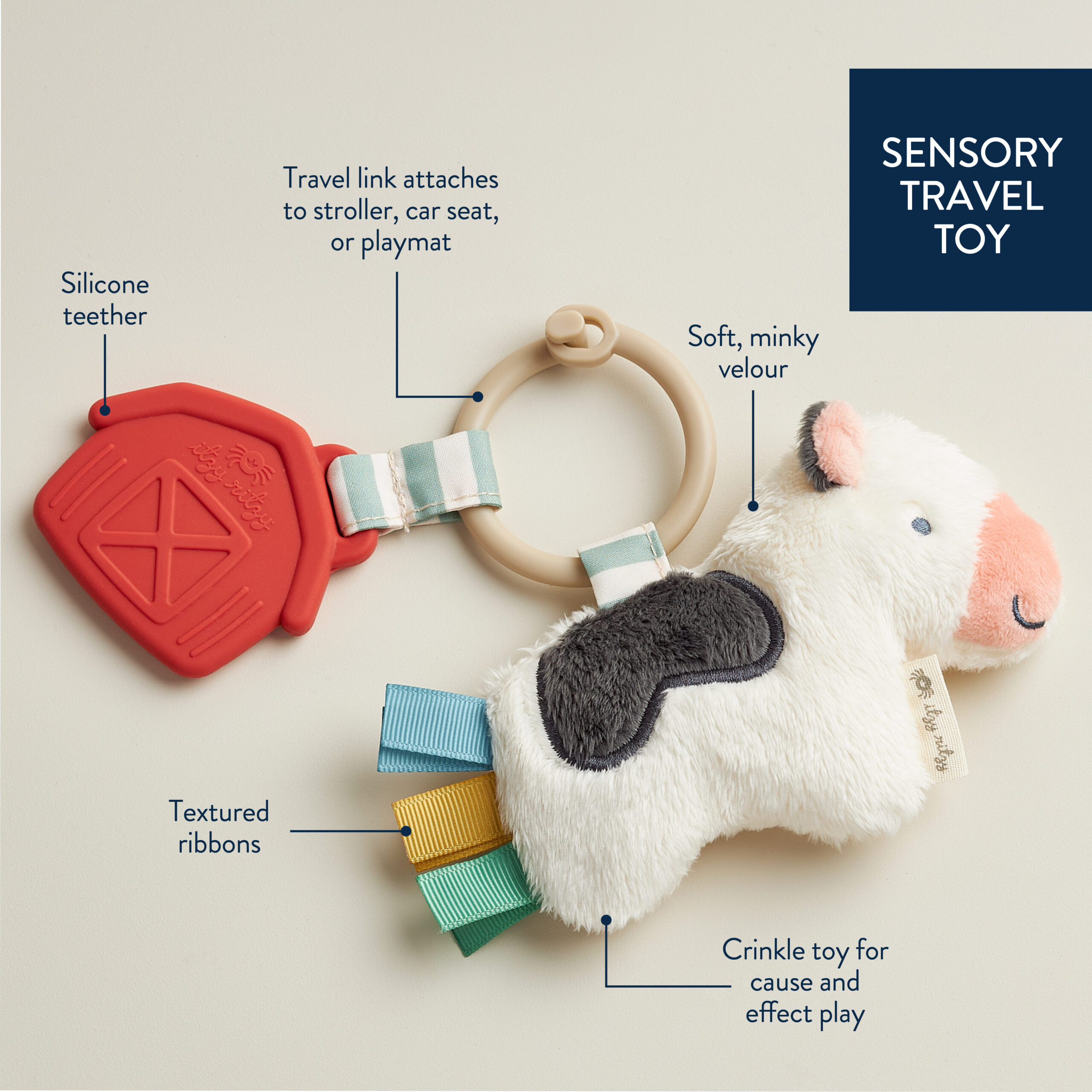 302701600 Itzy Pal™ Cow (2) A plush toy for travel featuring a silicone teether, soft velour material, textured ribbons, crinkle toy section, and a travel link for attaching to strollers, car seats, or playmats.