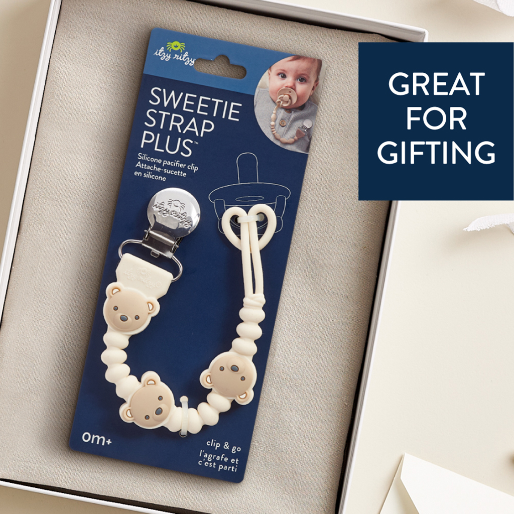 705101559 Sweetie Strap Plus™ Bear The Itzy Ritzy Sweetie Strap Plus Bear Silicone Pacifier Clip set, featuring bear-themed beads, is displayed in a box. The product tag and packaging are visible, and the text on the box reads "Great for Gifting.