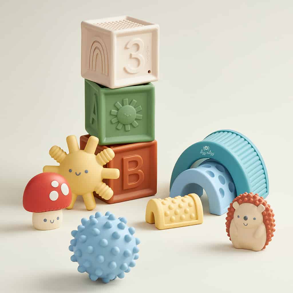 BL853201_Itzy_Ritzy_Toy_Itzy_Blocks_DigitalShelf A collection of Itzy Ritzy Sensory Blocks 10-Piece Set including stackable blocks, a textured ball, and whimsical animal-shaped toys on a light background.