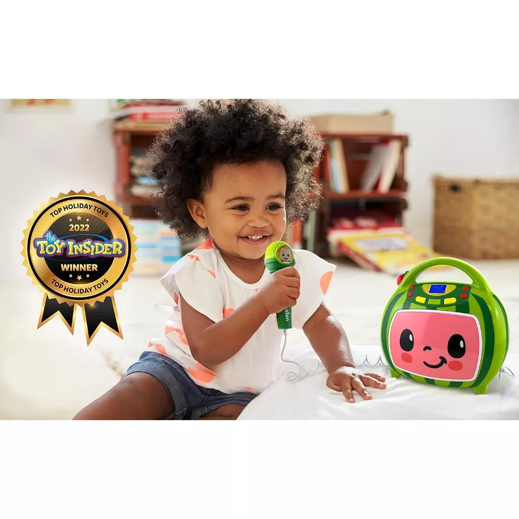 CoComelon Bluetooth MP3 Player Sing-Along Boombox Speaker With Karaoke Microphone USB Toddler Kids (8) A child playing with a green toy microphone and cassette player. A "Toy Insider Top Holiday Toys 2022" award badge is on the left side of the image.
