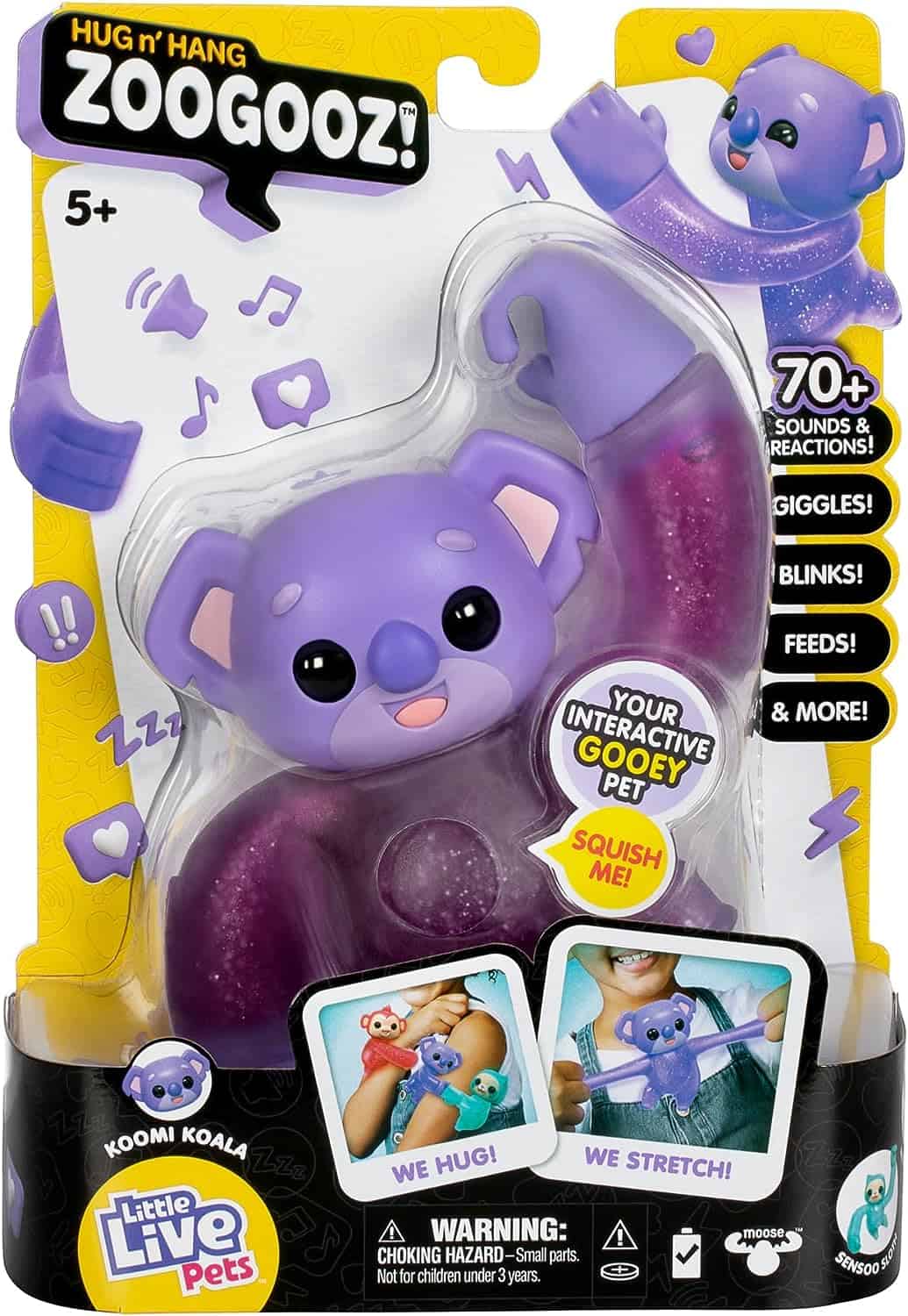 Little Live Pets Hug n' Hang Zoogooz - Koomi Koala. an Interactive Electronic Squishy Stretchy Toy Pet with 70+ Sounds & Reactions. Stretch, Squish and Link Their Hands (1) A packaged toy labeled "Hug n' Hang Zoogooz!" featuring a purple koala named Koomi Koala. It advertises over 70 sounds and reactions, including giggles and blinks. Suitable for ages 5 and up.