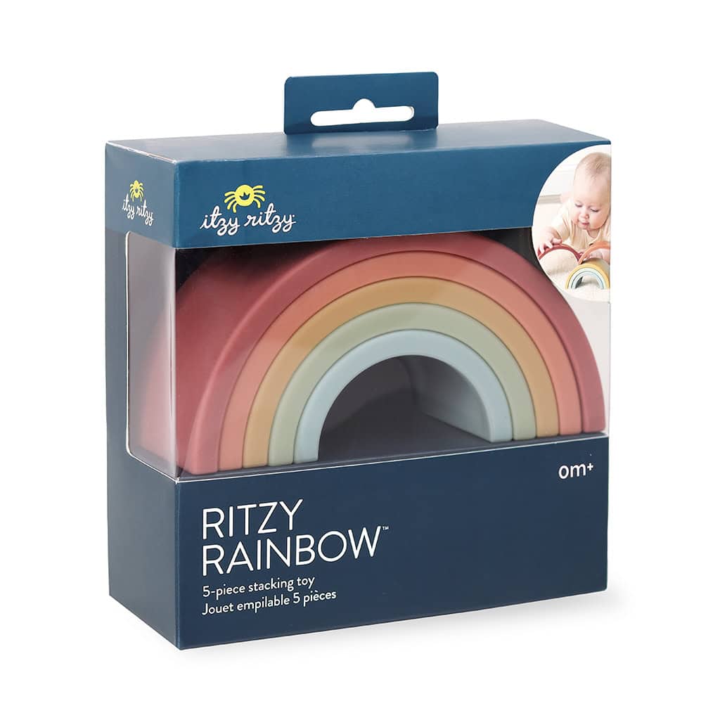 RS8548 Itzy Ritzy Rainbow Stacking Toy (3) A "ritzy rainbow" 5-piece stacking toy in shades of red, orange, and yellow, packaged in a box with a viewing window and a picture of a baby playing with it.