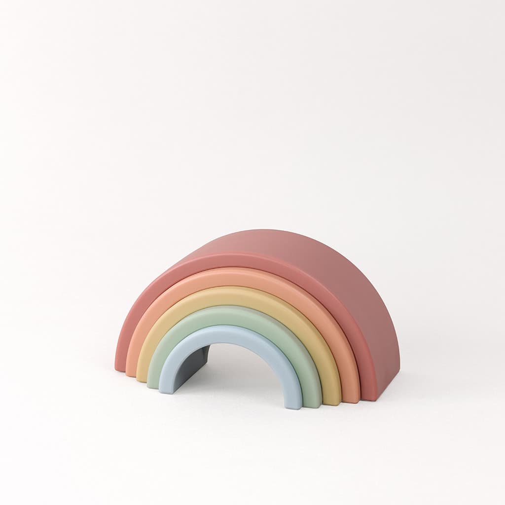 RS8548 Itzy Ritzy Rainbow Stacking Toy (5) A stack of colorful wooden rainbow arches arranged from largest to smallest against a plain white background.
