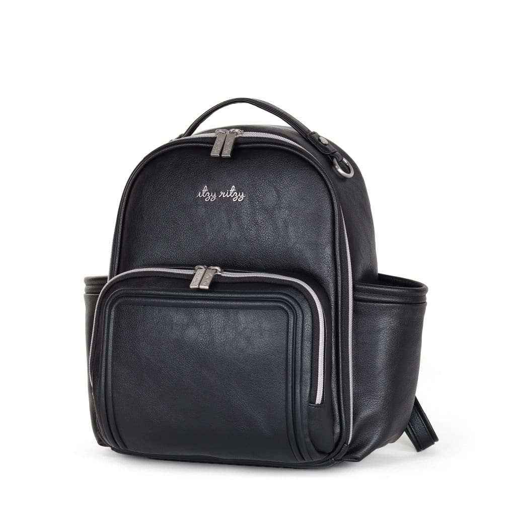 itzy-ritzy-101401619-itzy-mini-plus-backpack-noir-10 A sleek black backpack with a front zipper pocket, side compartments, and a top handle. The bag features a loop for hanging and the words "itsy ritzy" embroidered on the front.