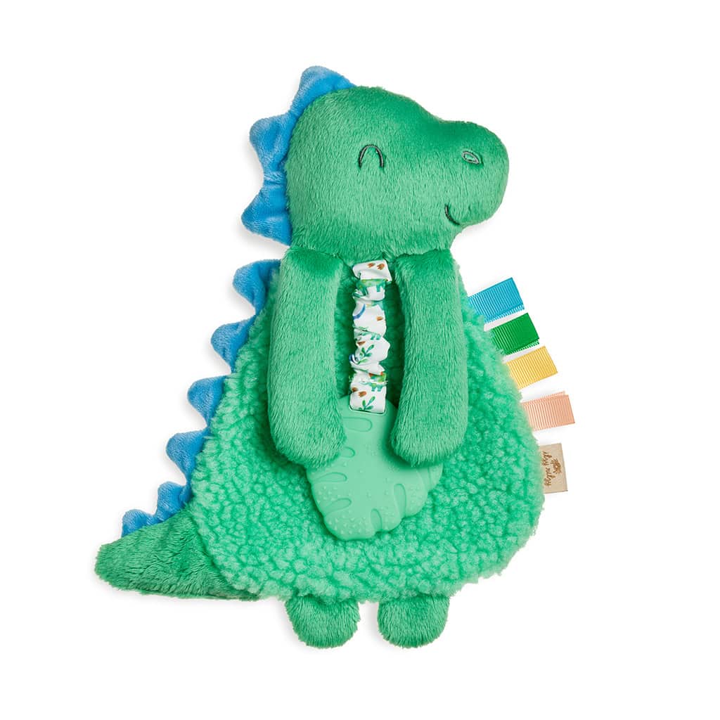 itzy-ritzy-lov8085-itzy-lovey-green-din A green plush dinosaur toy with a textured belly, blue spikes along its back, and colorful fabric tags on its side. The toy has a small floral-patterned bow tie.