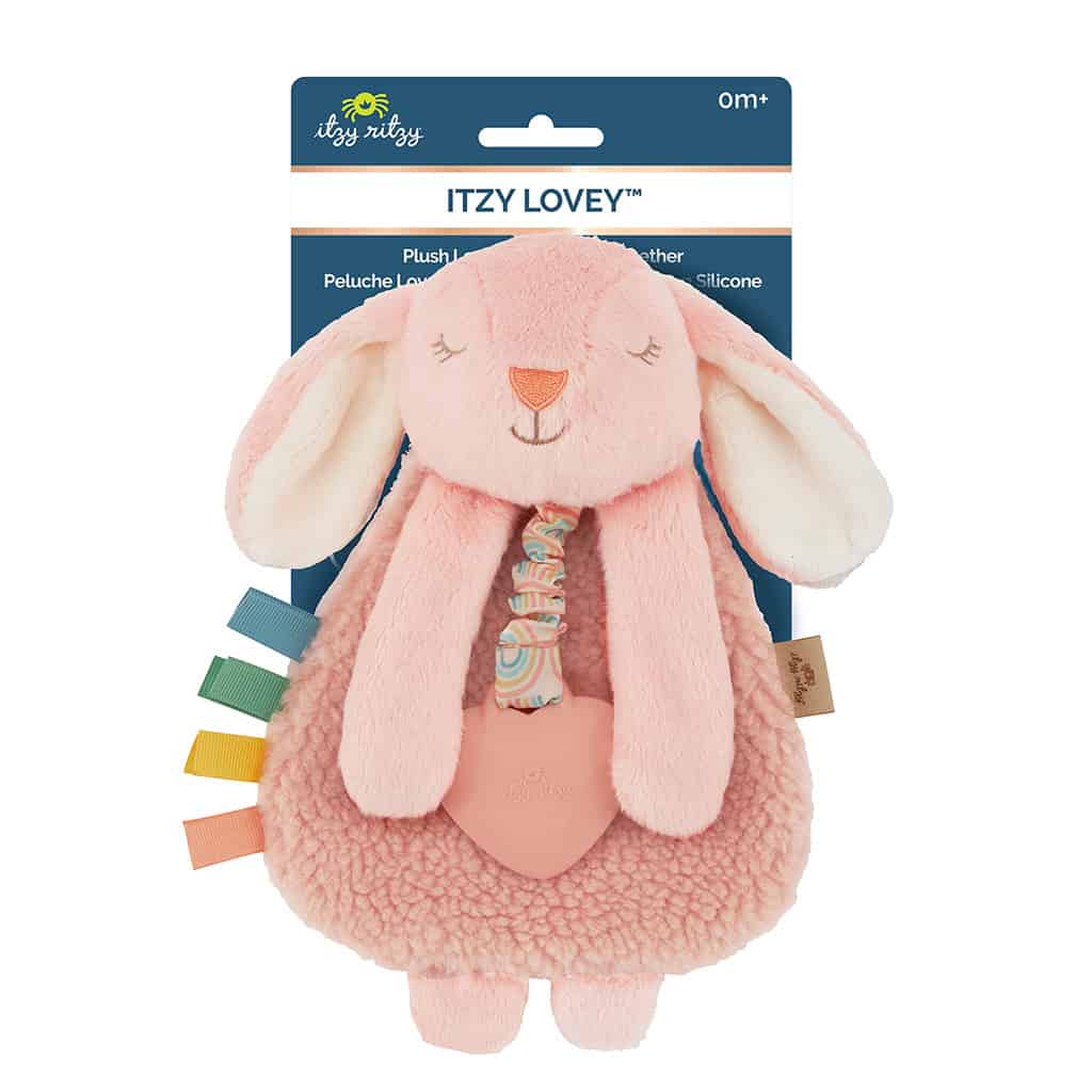 itzy-ritzy-lov8447-itzy-lovey-bunn A soft pink plush toy resembling a bunny, labeled "Itzy Lovey" by Itzy Ritzy, with a teething ring and attached colorful fabric tags. Suitable for infants.
