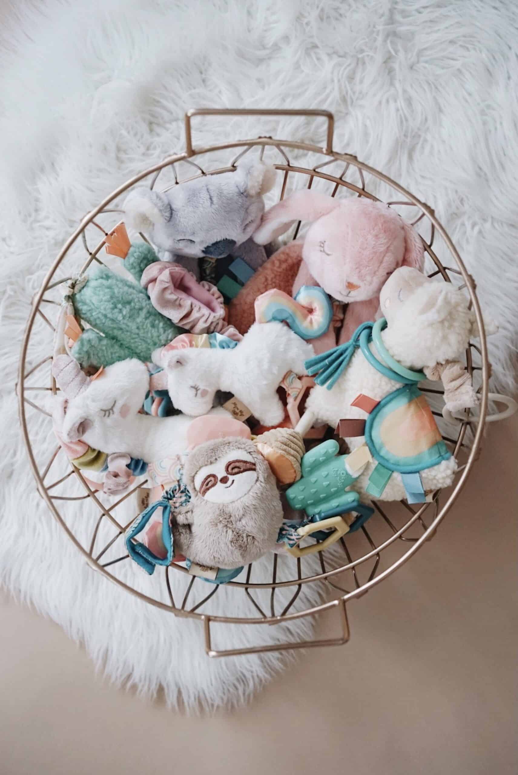Processed with VSCO with a6 preset A round wire basket filled with various stuffed animals and plush toys sits on a white fluffy rug.