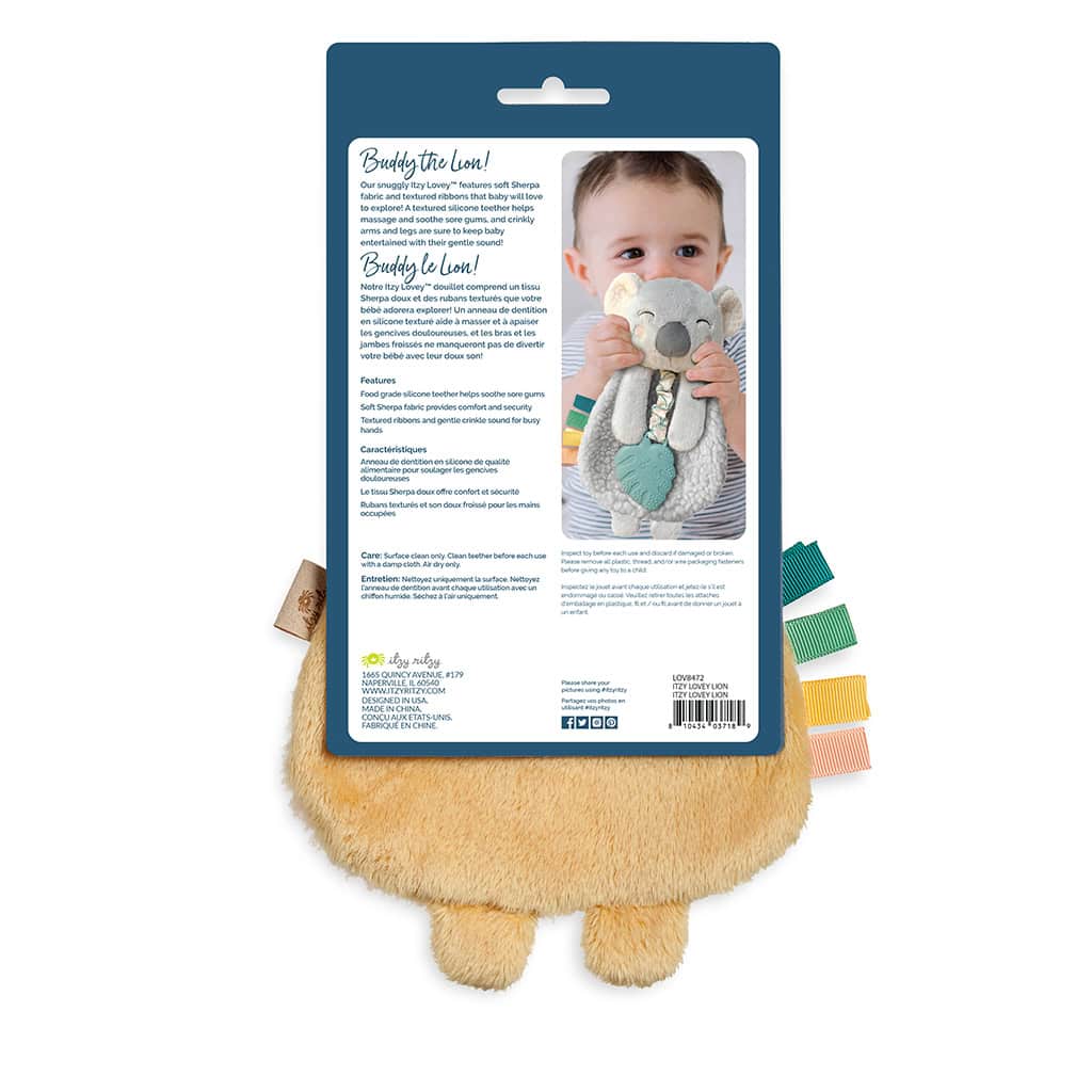 itzy-ritzy-lov8472-itzy-lovey-lion-2 Back of a product packaging showing a child holding a plush lion toy. The packaging details and product information are written on it. The toy's yellow fur and leg details are partially visible.