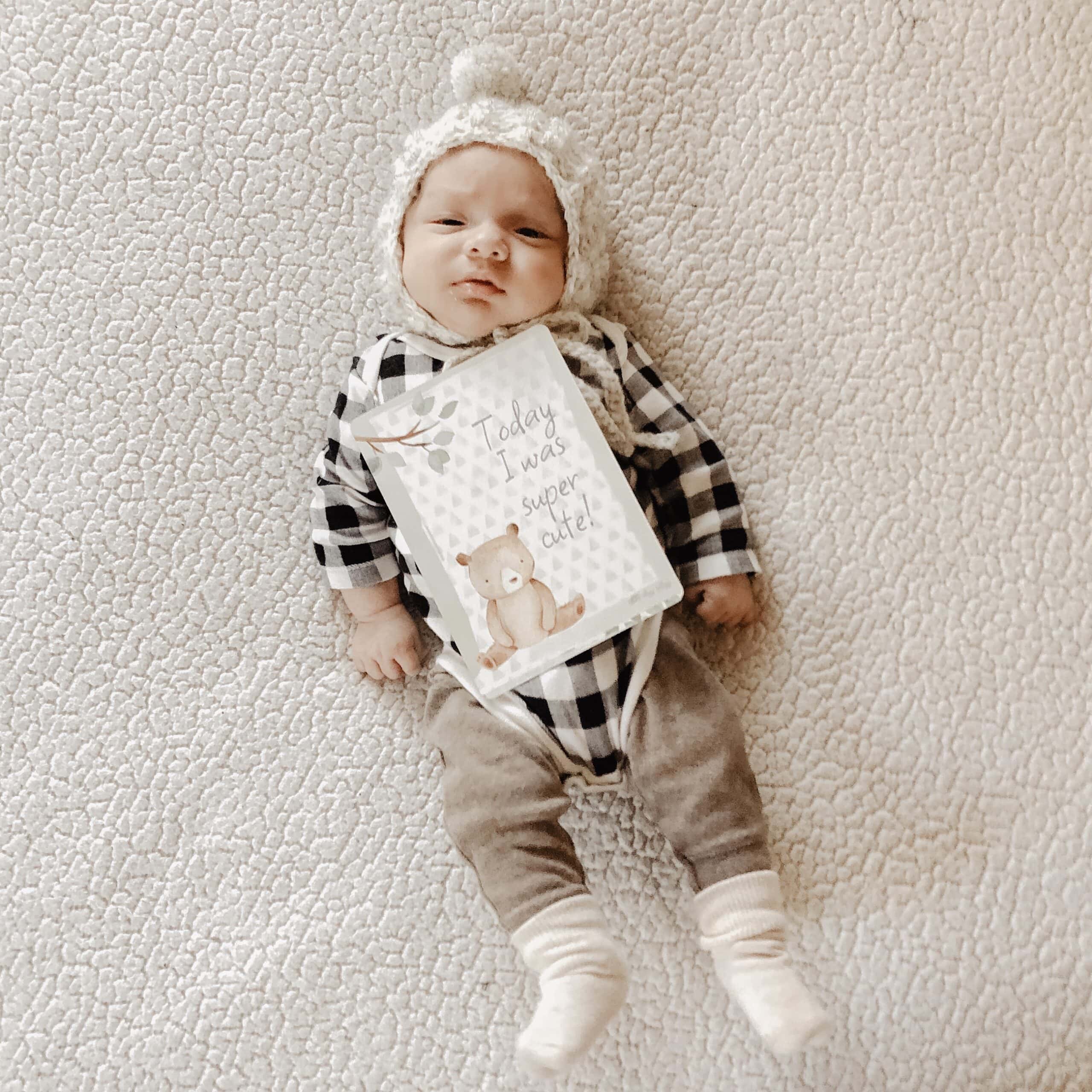 itzy-ritzy-mc8383-itzy-moments-woodland-15 A baby laying on a blanket with a teddy bear.