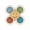 A sensory toy in the shape of a flower with five rounded petals, each featuring different textures and colors. The center is yellow with a smiling face.