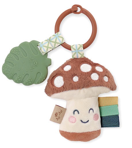 A Itzy Ritzy - Itzy Pal - Plush Pal Infant Toy with Silicone Teether featuring a smiling mushroom plush with a teething leaf and colorful rings attached to a wooden ring.